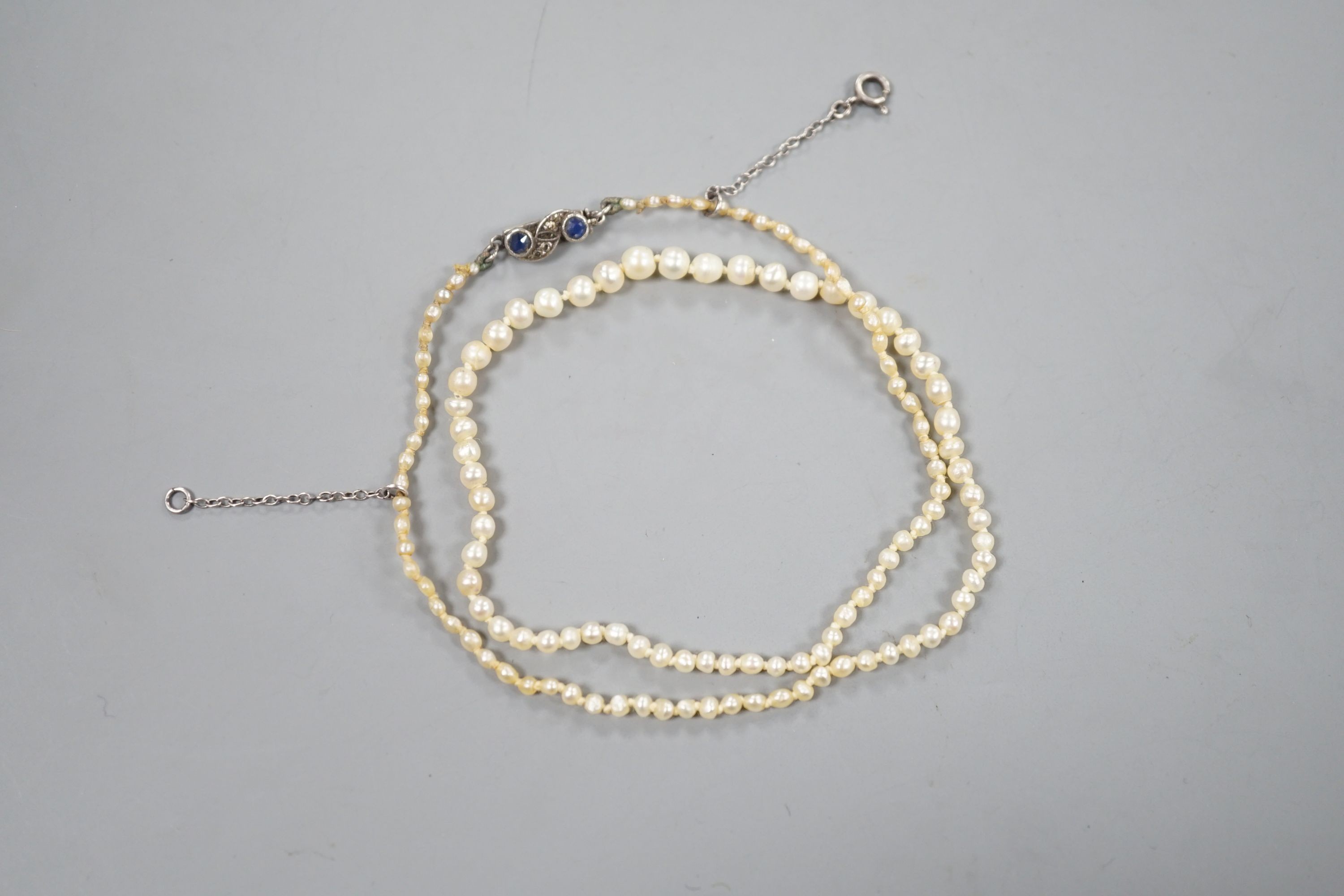 An Edwardian single strand graduated natural saltwater pearl necklace, with sapphire and diamond chip set clasp, 38cm, gross weight 5.7 grams, with accompanying Gem & Pearl Laboratory report dated 1/2/2022.